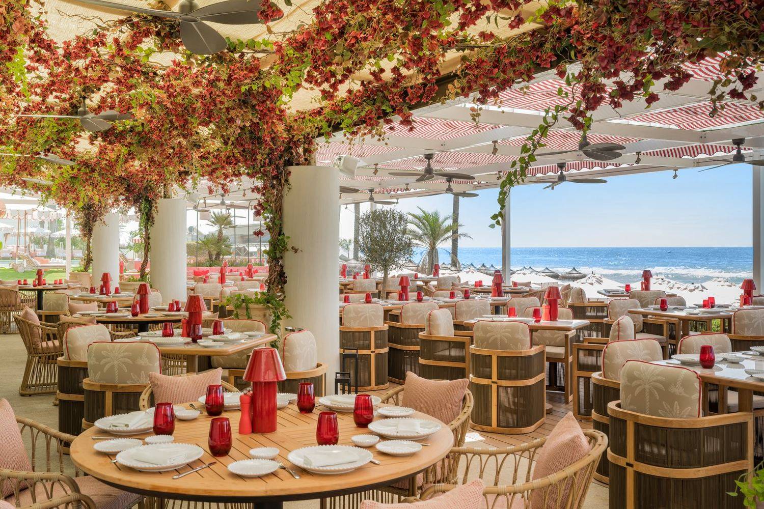 Amù at Gran Hotel Marbella, tables under red bougainvillea with the sea beyond.