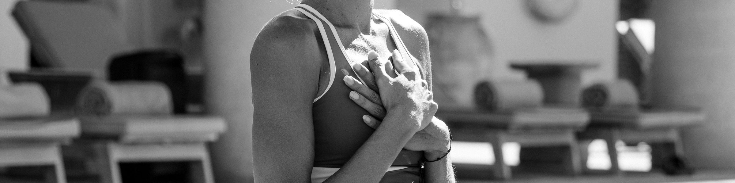 En blanco y negro, una mujer con las dos manos sobre el pecho.